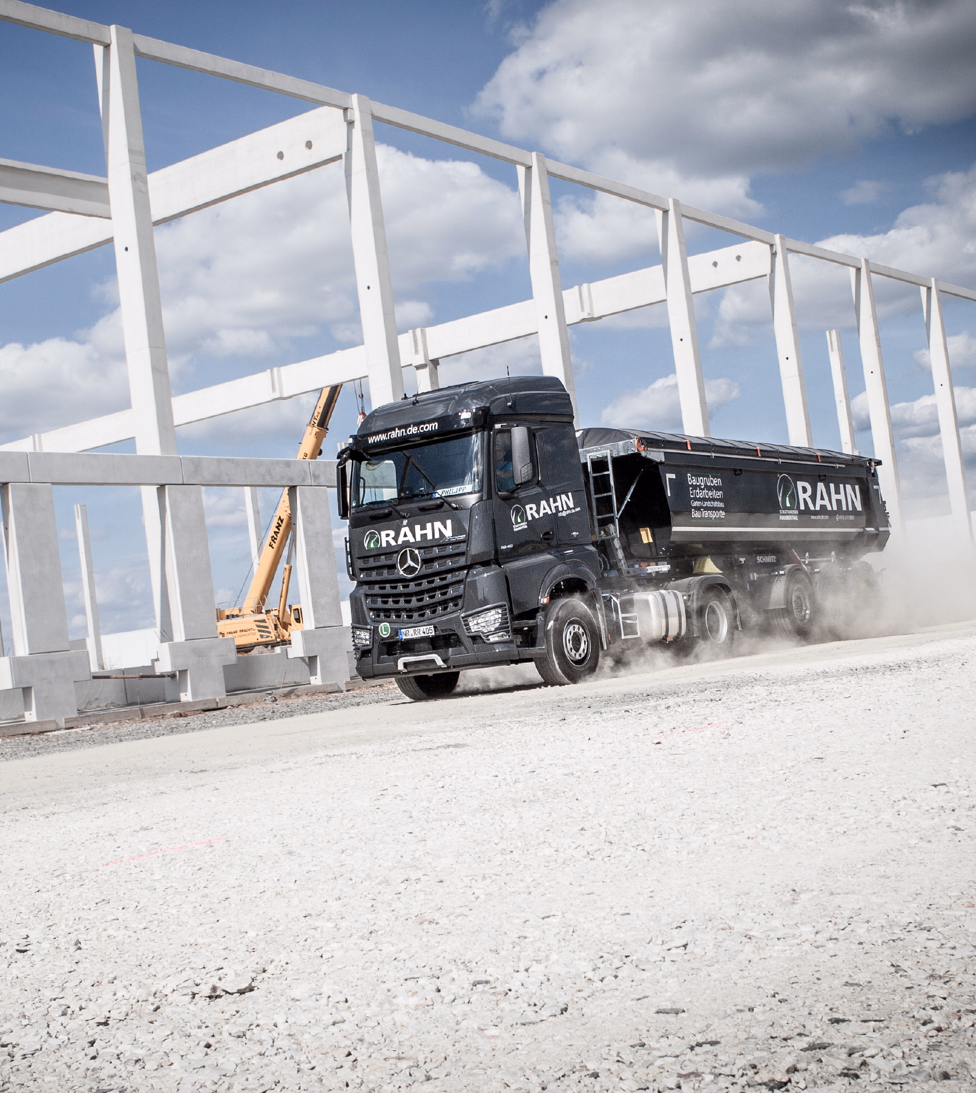 RAHN Kipper-LKW auf einer Baustelle vor einem Betonskelettbau